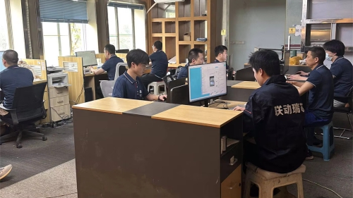 This is the office scene of a sales team at a linear drive module manufacturer. Staff members are communicating with clients and negotiating business, providing consulting services on ball screw modules and automated linear drive solutions.